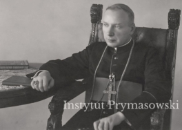 Biskup S. Wyszynski siedzacy na fotelu.Postac do kolan. Prawa reka oparta na stole.